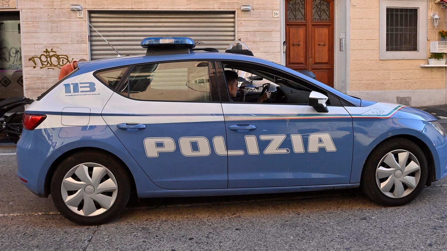Un'auto della polizia davanti al palazzo dove è morto il bimbo (Foto Novi)