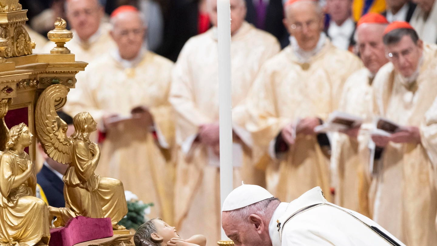 Papa Francesco bacia il Bambino nella notte di Natale (Ansa)