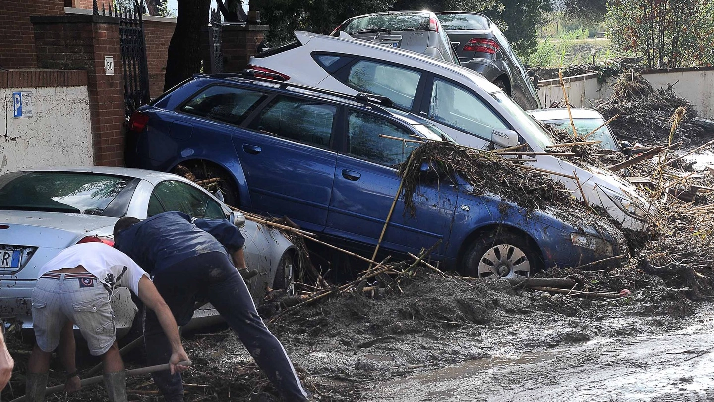 Livorno, al lavoro nelle strade piene di fango (Lapresse)
