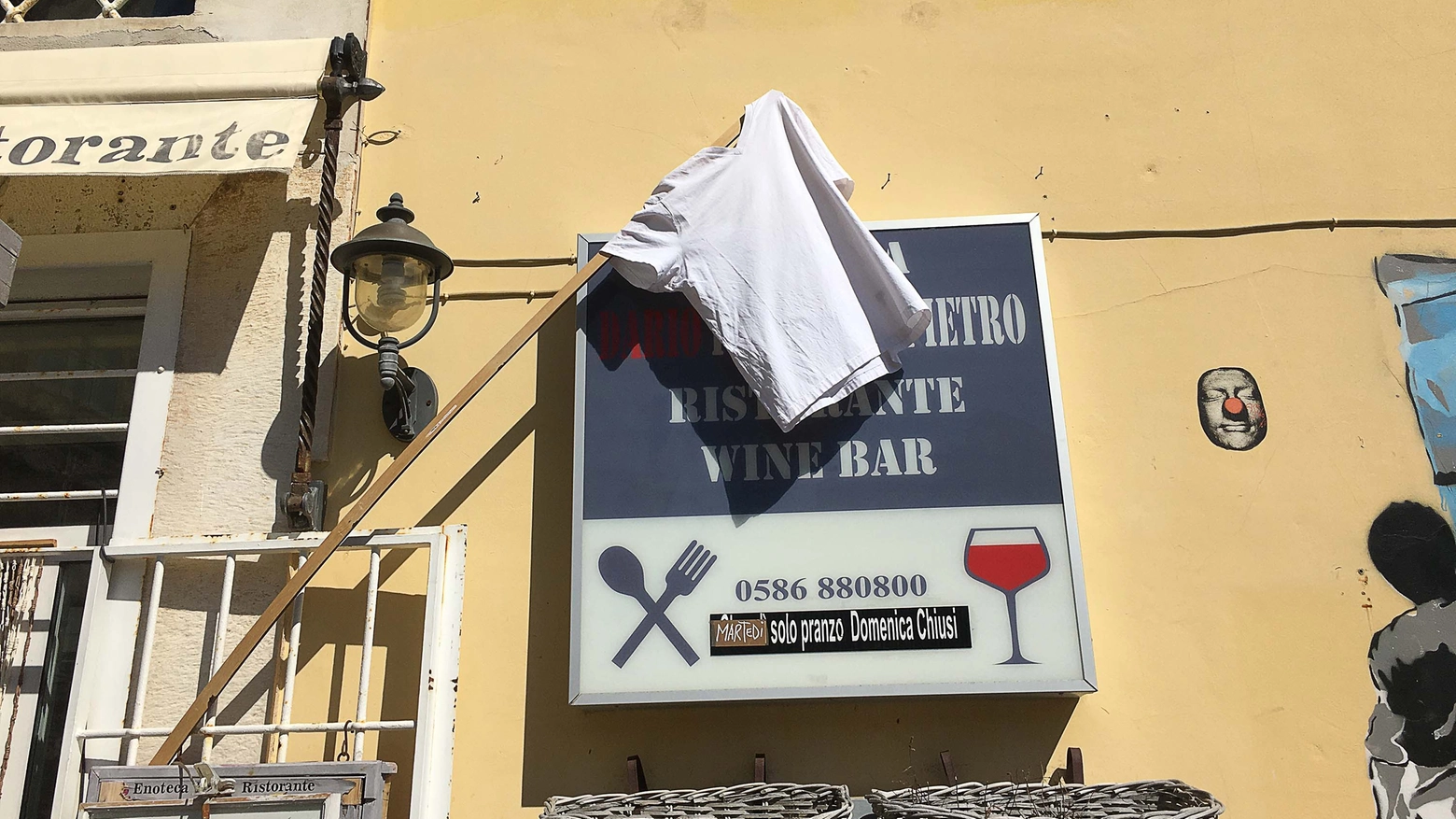 Maglietta bianca sull'insegna di un ristorante (Foto Lanari)