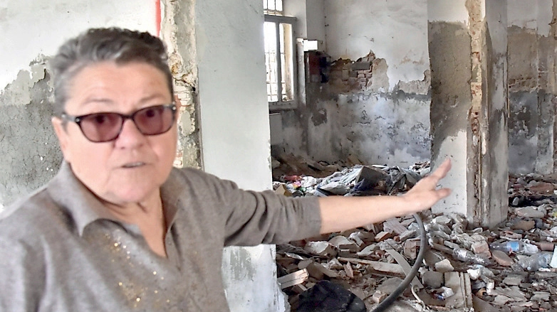 Lucia Gori mostra i rifiuti abbandonati nella palazzina con la torretta