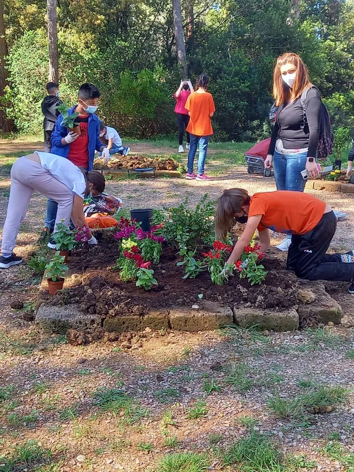 Bambini a lavoro nel giardino della scuola per coltivare piante e erbe aromatiche