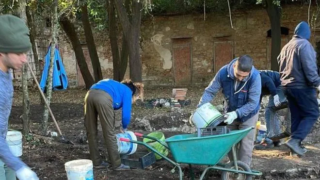 Volontari ripuliscono il parco a villa Maurogordato, a destra la serra liberty