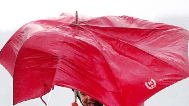 20040306 - NAPOLI - CRO - MALTEMPO:BLOCCATI COLLEGAMENTI VELOCI CON ISOLE GOLFO NAPOLI.                                        Due passanti in difficolta' con il loro ombrello per il forte vento sul lungomare Caracciolo di Napoli.                                                Ciro Fusco   ANSA-CD